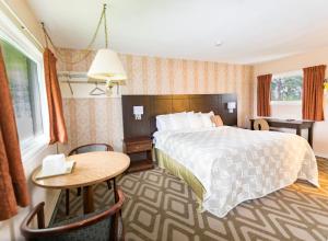 a hotel room with a large bed and a table at Countryside Inn in Kingston