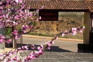 a sign for a restaurant with pink flowers in the foreground at Hotel y Cabañas una Cosita de Zacatlán in Zacatlán