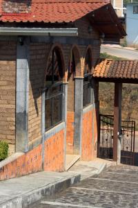 an entrance to a brick building with a red roof at Hotel y Cabañas una Cosita de Zacatlán in Zacatlán