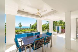 uma sala de jantar com mesa e cadeiras e vista para o oceano em White Stone - Luxurious Sunset View 4 Bed Pool Villa em Nathon
