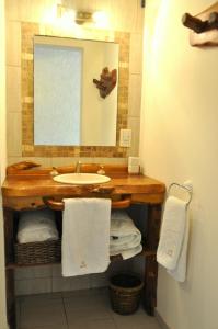 y baño con lavabo, espejo y toallas. en Complejo Abaurrea en Mendoza