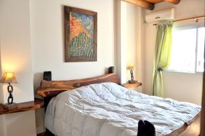 1 dormitorio con 1 cama y una pintura en la pared en Complejo Abaurrea en Mendoza