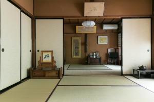 a room with a hallway with white doors and carpet at Sumiyoshi Ryokan in Takayama