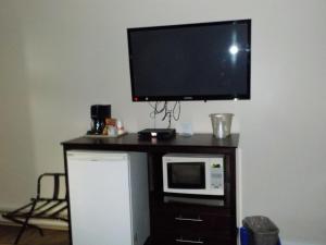 a tv sitting on top of a wooden desk next to a microwave at Econolodge Vernon in Vernon