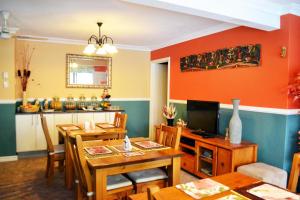 Palms Bed & Breakfast في بيرث: غرفة طعام مع طاولة وتلفزيون