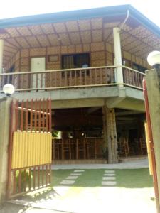 a building with a balcony and a wooden gate at Greenhut Pension & Bar in Jagna