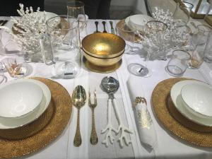 a table with plates and silverware on a white table cloth at Panoramic views in luxurious brand new apartment in Sydney