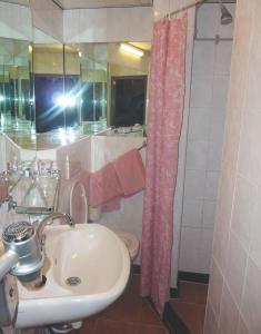 a bathroom with a sink and a pink shower curtain at Nadia Hotel in Amsterdam