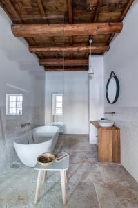 a white bathroom with a tub and a sink at Boutique hotel Mezi plutky in Čeladná