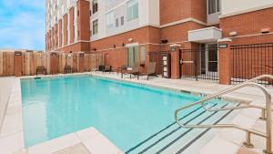 uma piscina com cadeiras e um edifício em Hyatt Place Austin/Round Rock em Round Rock