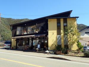 a yellow building on the side of a street at Kumano Backpackers in Tanabe