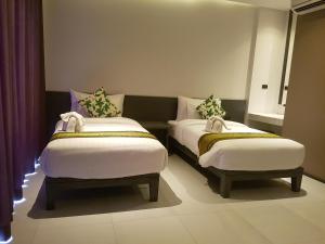 a room with two beds in a room with a window at Maehaad Bay Resort - SHA Plus in Mae Haad +33 photos