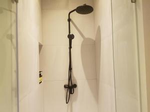 a shower with a black shower head in a bathroom at Maehaad Bay Resort - SHA Plus in Mae Haad