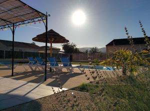 a group of chairs and umbrellas next to a pool at La Cigale - Pte des Gorges - Piscine privée chauffée in Vallon-Pont-dʼArc