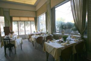 a dining room with tables and chairs and windows at Oceanis in Thessaloniki