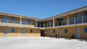 an empty parking lot in front of a building at Stopforths Motel in Hokitika