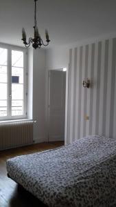 a bedroom with a bed and a large window at Gite Au Coeur De Volnay in Beaune