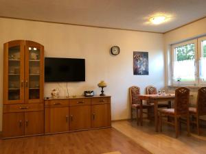 ein Wohnzimmer mit einem Esstisch und einem Flachbild-TV in der Unterkunft Gästehaus Katharina in Müllenbach