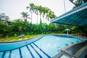 a large swimming pool with palm trees in the background at The Renai Cochin in Cochin