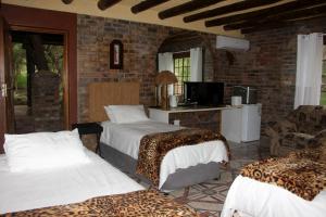 a bedroom with two beds and a room with a tv at Jabula Kruger Safari Lodge in Marloth Park +65 photos