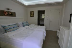 a large white bed with pillows in a bedroom at Dalyan Risus Suite in Çeşme