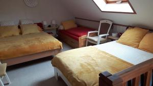ein Schlafzimmer mit 2 Betten, einem Sofa und einem Stuhl in der Unterkunft Le Mouton Blanc in Couloisy