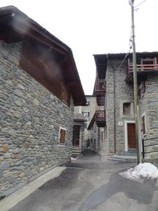 een steegje in een oud stenen gebouw met sneeuw op de grond bij Baita Stampa in Chiesa in Valmalenco