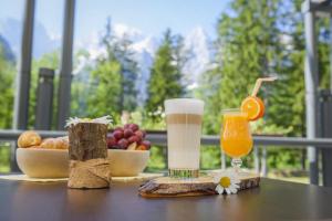 a table with a drink and a bowl of fruit at Špik Alpine Resort in Kranjska Gora