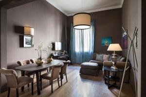uma sala de estar com uma mesa e cadeiras e um sofá em Palazzo Branchi em Florença
