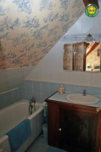 ein Badezimmer mit einem Waschbecken und einer Badewanne in der Unterkunft La ferme de la vallée in Auchy-au-Bois