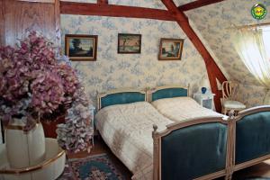 ein Schlafzimmer mit einem Bett und Blumen an der Wand in der Unterkunft La ferme de la vallée in Auchy-au-Bois