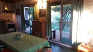 Habitación con mesa y cocina con puerta corredera de cristal. en Armonía, en Villa Serrana
