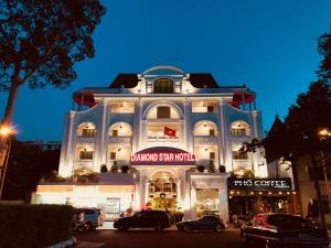 un gran edificio blanco con coches estacionados frente a él en Diamond Star Hotel en Vung Tau