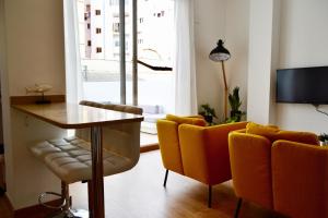 バレンシアにあるHola Valencia - Holiday Apartmentsのリビングルーム(テーブル、黄色い椅子付)