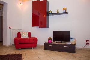 a living room with a red chair and a television at Casa Libertà 32 in Marsala