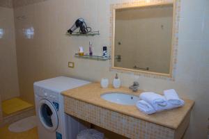 a bathroom with a sink and a washing machine at Casa Libertà 32 in Marsala