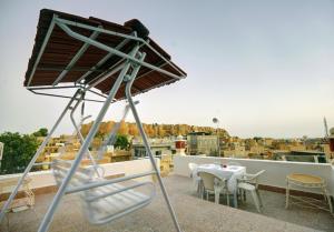 ジャイサルメールにあるHotel Jaisal Palaceのバルコニーの上に置かれたテーブル付きの椅子