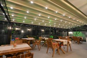 a restaurant with wooden tables and chairs and lights at Dalyan Risus Suite in Çeşme