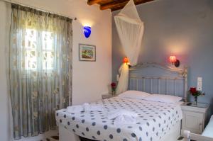 a bedroom with a white bed and a window at Lakki Village in Aegiali