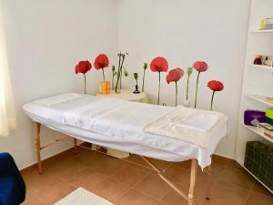 een ziekenhuisbed met rode bloemen in een kamer bij Casa Rural El Covanchón in Prádena