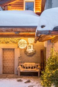 a bench on the side of a building in the snow at Saint Hubertus Resort in Breuil-Cervinia