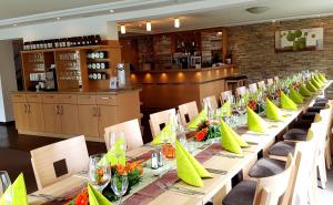 a long table with green napkins and flowers on it at Landhotel Sonnenhalde in Bad Boll