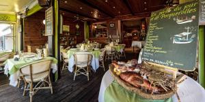 a restaurant with tables and chairs and a sign with a turkey at Hôtel Le Porquerollais in Porquerolles