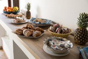 a table topped with plates of pastries and fruit at Cabrera House in Pozzallo +24 photos