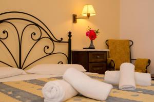 a bedroom with a bed with towels on it at Lakki Village in Aegiali