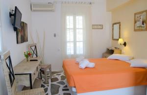 a bedroom with two beds and a television in it at Lakki Village in Aegiali