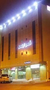a car parked in front of a building at night at Qsr Al Balsem Aparthotel in Unayzah