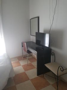 um quarto com uma secretária, uma televisão e uma cadeira em Hostal Cabañas em Carboneras de Guadazaón