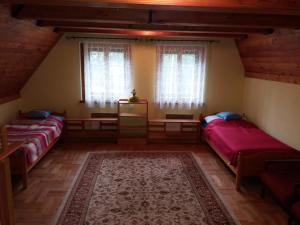 a attic room with three beds and a rug at Chalupa Anadělská Hora in Andělská Hora