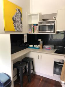 una cucina con bancone, sgabelli e forno a microonde di Gin Gin Budget Accommodation a Gin Gin